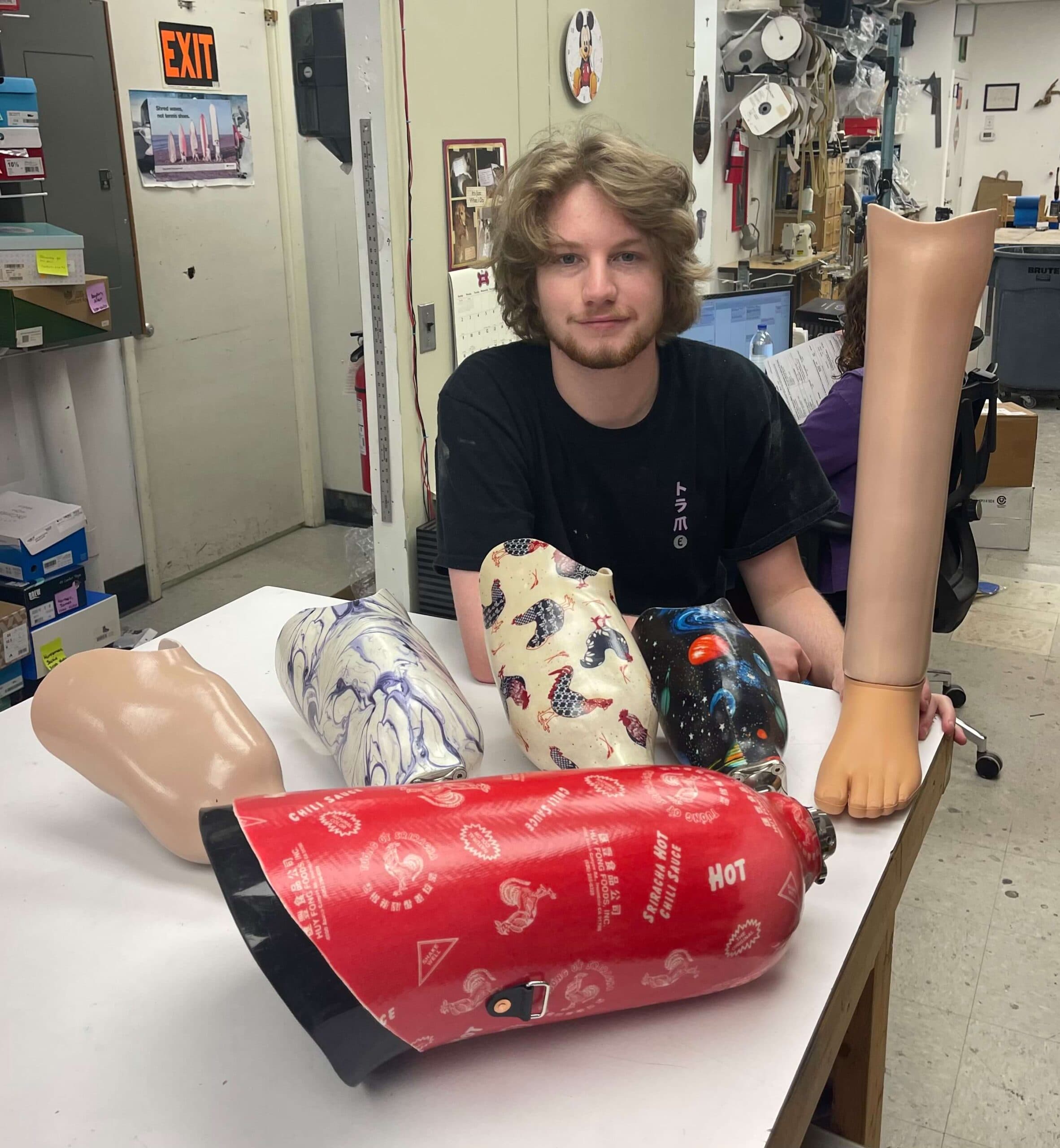 Tech assistant Shane Truesdale with several prosthetic sockets he helped to make